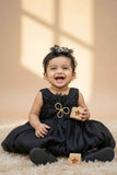 Black Party Frock with Oversized Floral Appliqué and Pleated Shine Finish For Girls