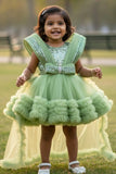 Pastel Green Party Frock With Layered Ruffles And Statement Bow and Tailback For Girls