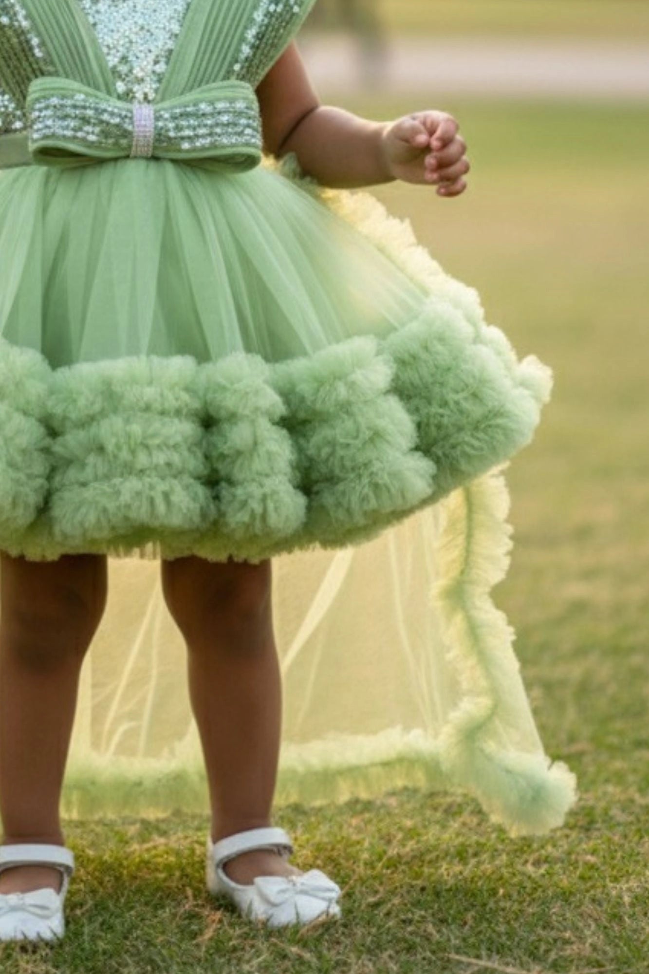 Pastel Green Party Frock With Layered Ruffles And Statement Bow and Tailback For Girls