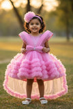 Pink Party Frock With Layered Ruffles And Statement Bow and Tailback For Girls