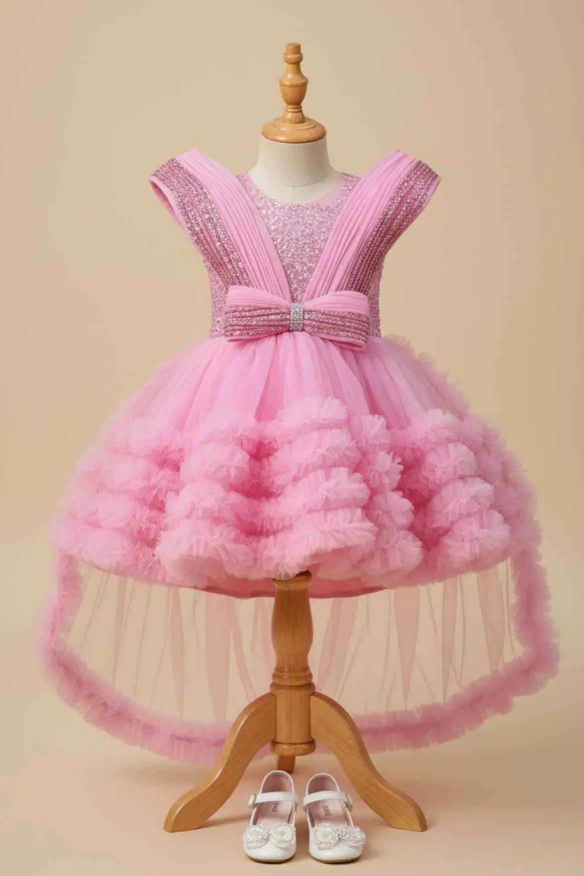 Pink Party Frock With Layered Ruffles And Statement Bow and Tailback For Girls