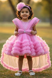 Pink Party Frock With Layered Ruffles And Statement Bow and Tailback For Girls