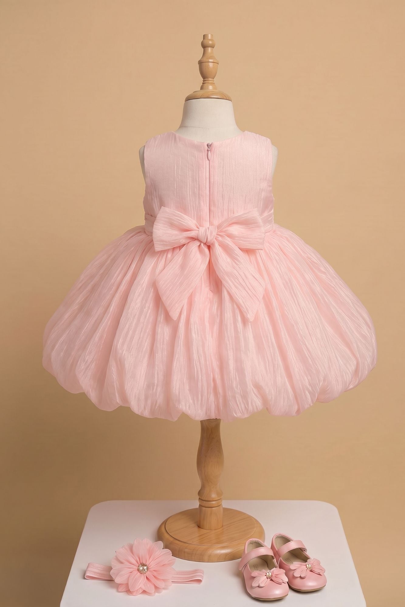 Peach Party Frock with Oversized Floral Appliqué and Pleated Shine Finish For Girls