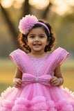 Pink Party Frock With Layered Ruffles And Statement Bow and Tailback For Girls
