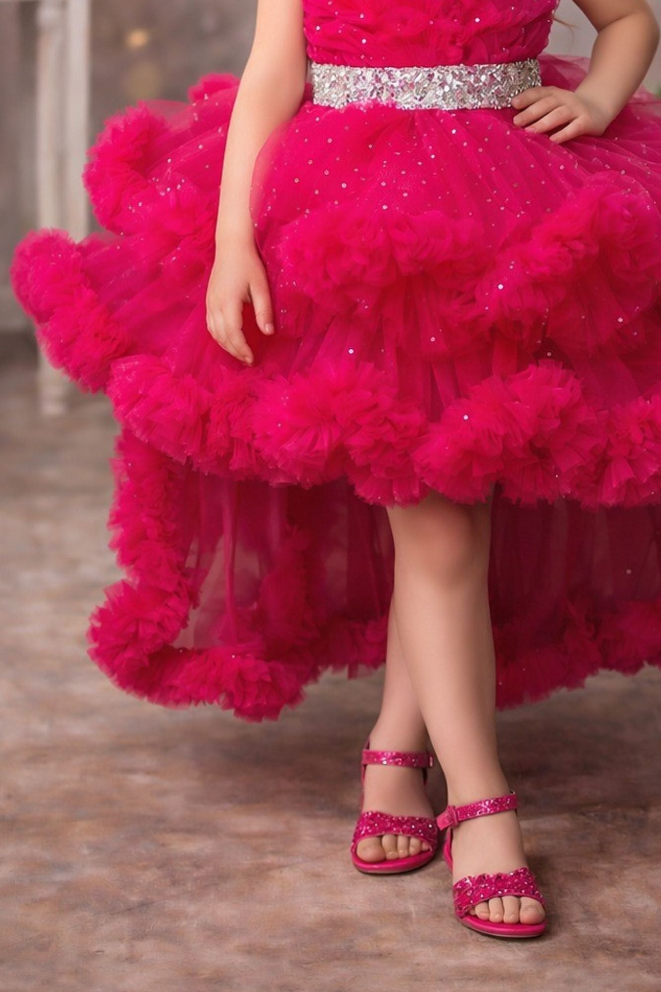 Girls Rani Pink High-Low Party Frock with Ruffled Layers And Embellished Waistbelt