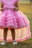 Pink Party Frock With Layered Ruffles And Statement Bow and Tailback For Girls