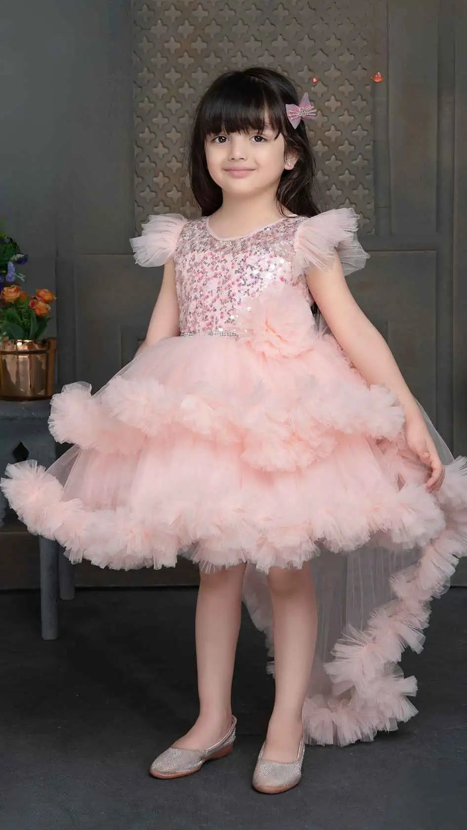 Peach Shimmer Tailback Party Wear Frock With Floral Embellishment For Girls
